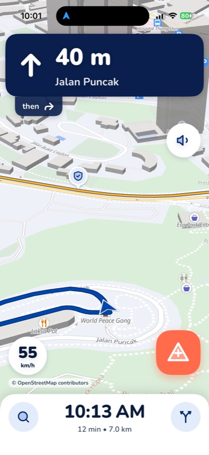 Manotu navigation screen: dark-blue turn banner with 40 m and Jalan Puncak, route line on the map, speedometer at 55 km/h and the coral report button
