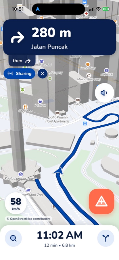Manotu navigation with the blue Sharing chip under the turn banner, showing the trip is being shared live